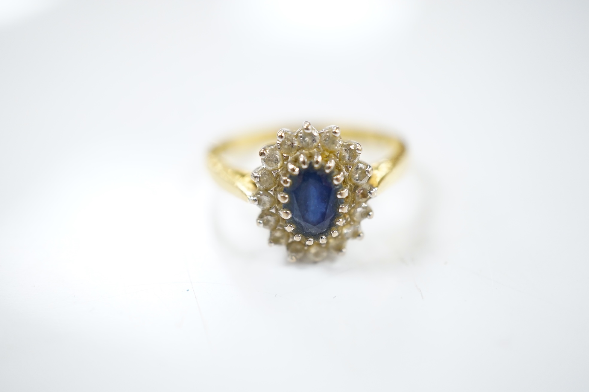 A modern 18ct gold, sapphire and diamond set oval cluster ring, size P/Q, gross weight 4.9 grams. Condition - fair